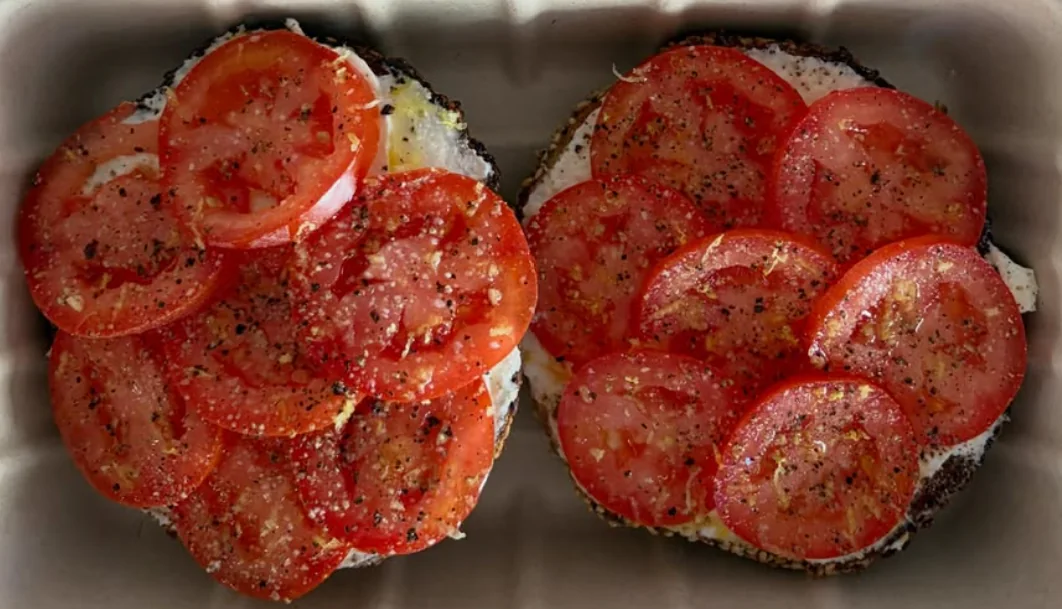 Hjemmelavet sesambagel med cream cheese, tomat, revet citron og olie